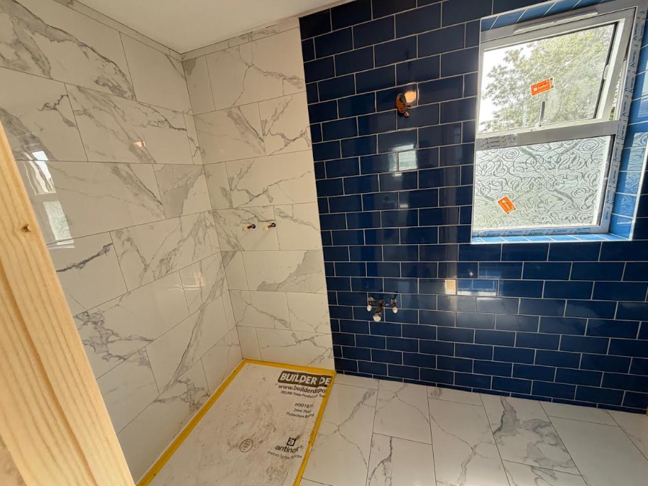 Bathroom renovation with marble and navy tiling
