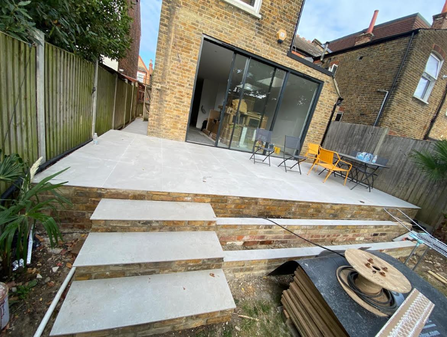 Modern garden patio extension with light stone tiling