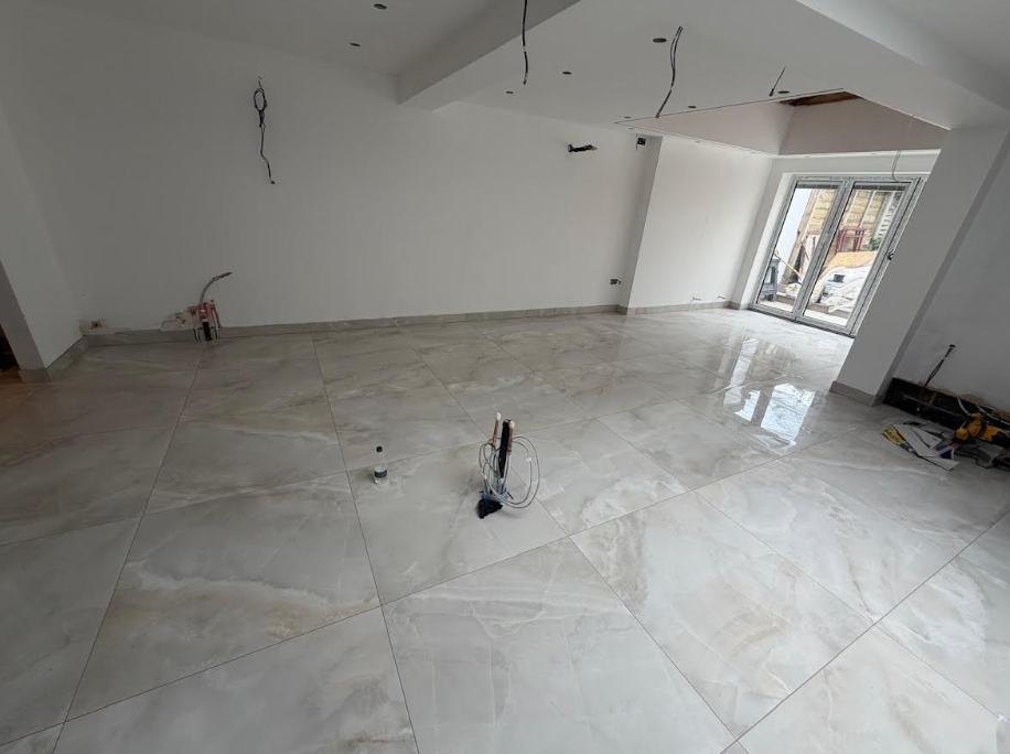 A professional realistic architectural photograph of a tiled interior project for GT Tiles, showing finished installation with clean precise lines and professional workmanship